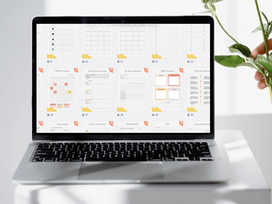 Laptop displaying a spreadsheet on a white surface with a plant