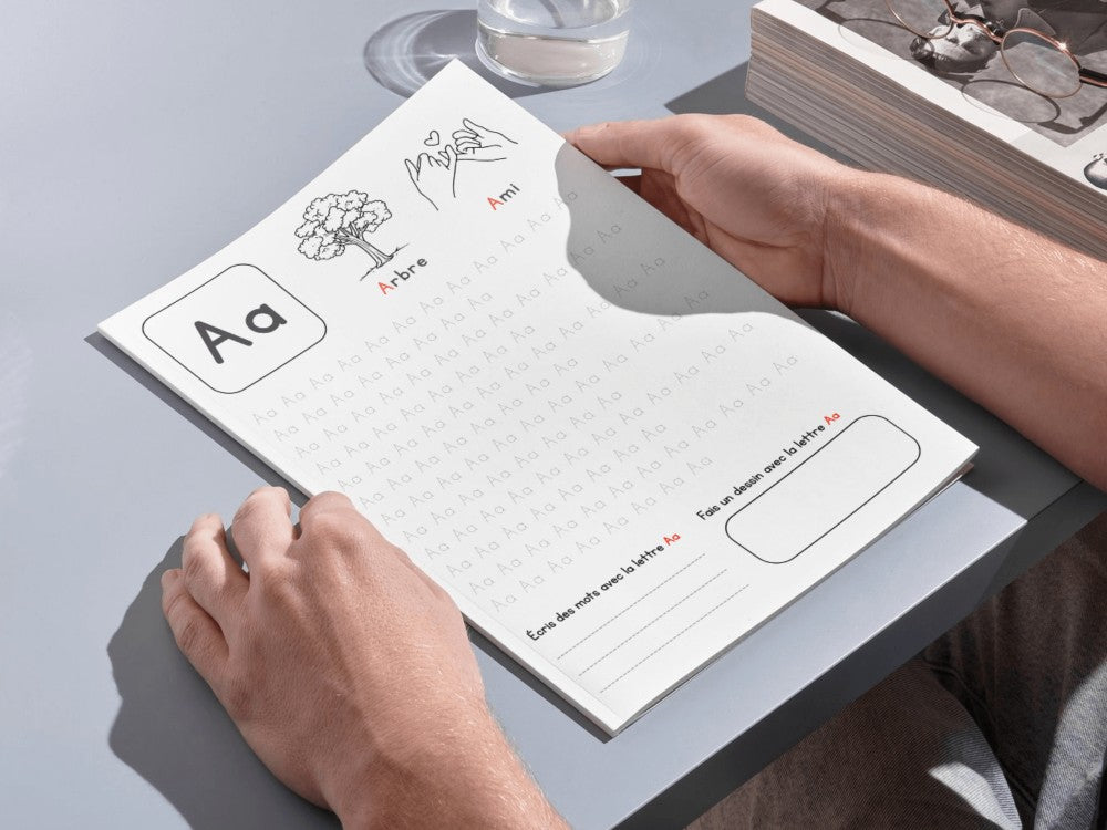 Person holding a notepad with educational content on a light gray surface