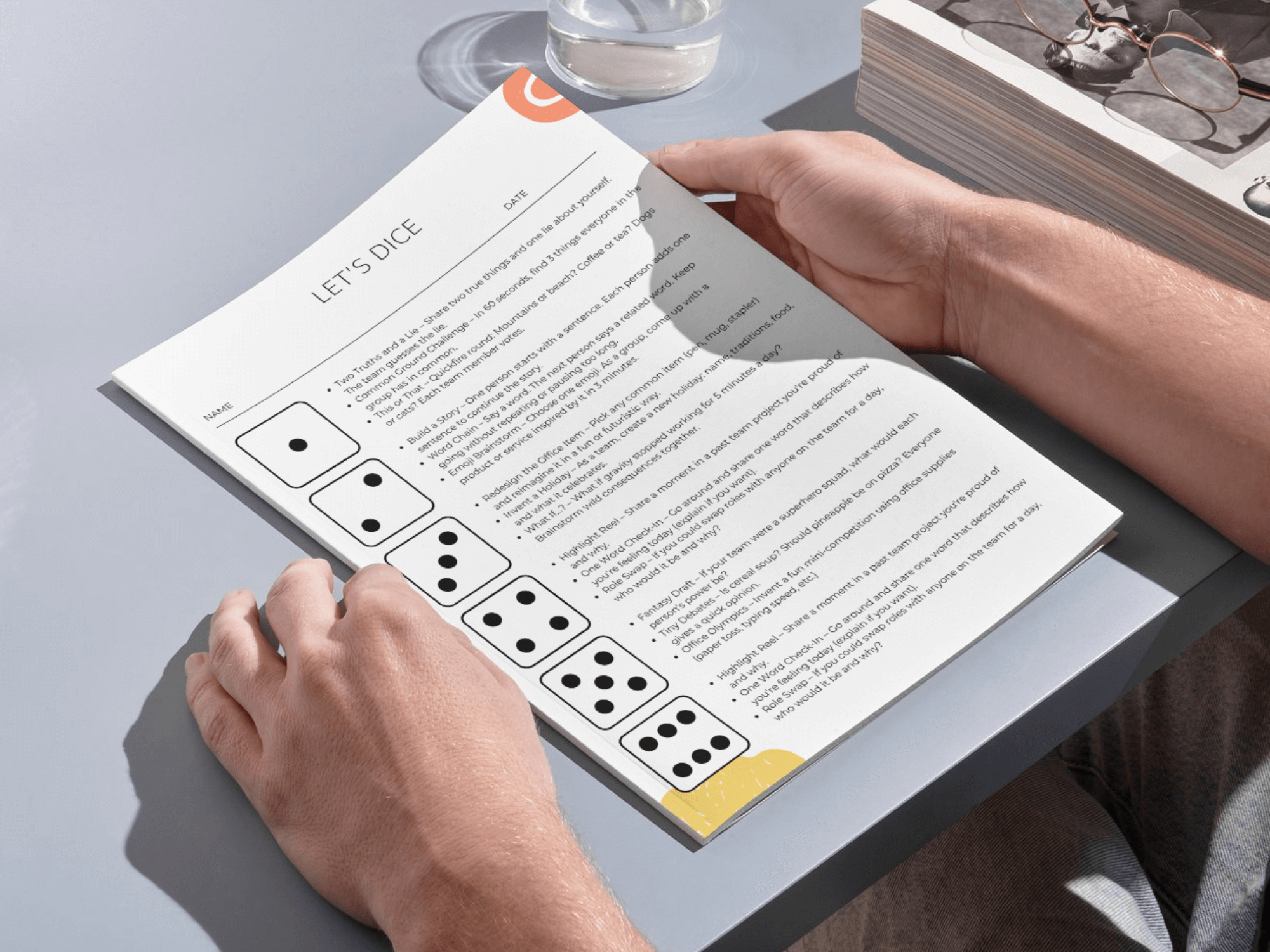 Person holding a game manual with dice on a table