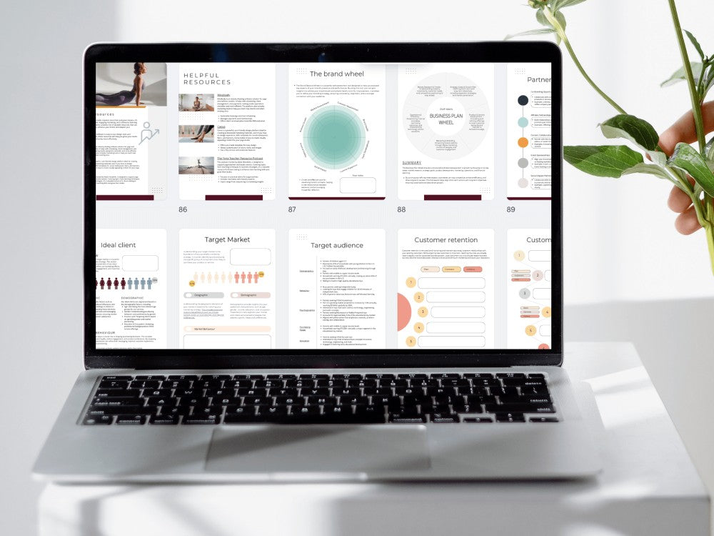 Laptop displaying a business plan template on a white desk with a plant