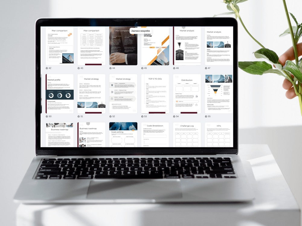 Laptop displaying a webpage on a white surface with a plant in the background