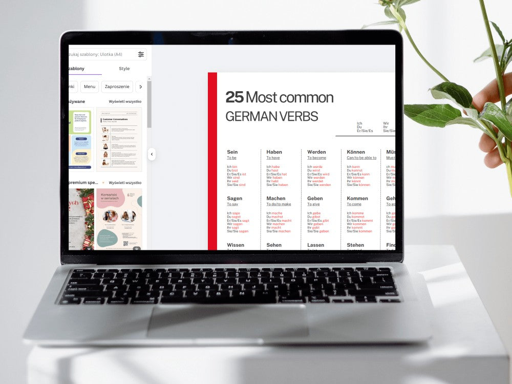 Laptop displaying a German verb list on a white surface with a plant.