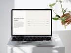 Laptop on a white surface with a hand holding a plant, displaying a branding document.