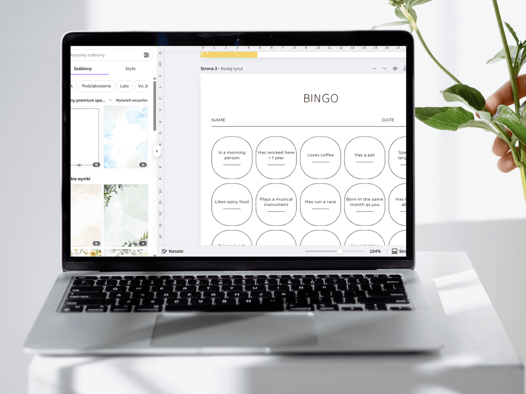 Laptop displaying a digital bingo game on a white surface with a plant in the background