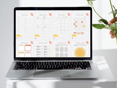 Laptop displaying a digital calendar on a white surface with a plant in the background