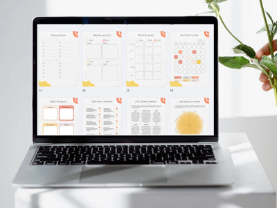 Laptop displaying a digital calendar on a white surface with a plant in the background