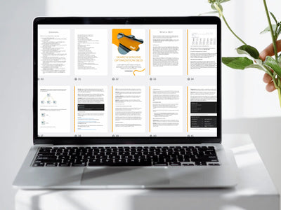 Laptop displaying a document on a white surface with a plant in the background