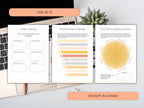 Open book with branded design elements on a desk with a laptop and plant.
