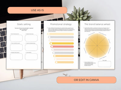 Open book with branded design elements on a desk with a laptop and plant.
