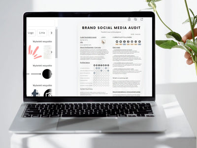 Laptop displaying a brand social media audit on a white surface with a plant