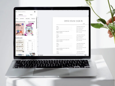 Laptop displaying a form on a white surface with a hand holding a plant.