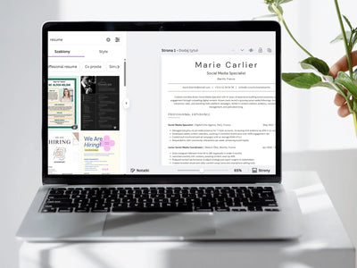 Laptop displaying a resume on a white surface with a plant in the background