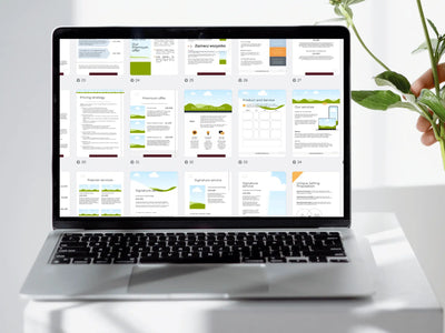 A laptop screen displaying a grid of many colorful business plan pages being edited in a design software