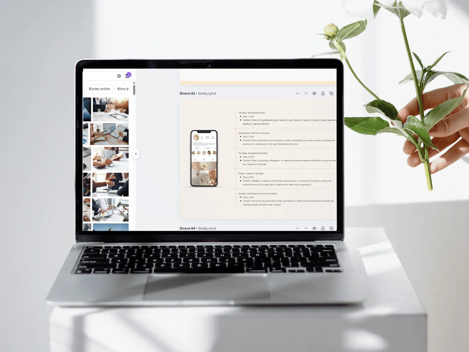 A silver laptop sits on a white pedestal, displaying a website mockup on its screen. A hand holding white flowers is visible on the right side of the frame against a bright, clean white background.