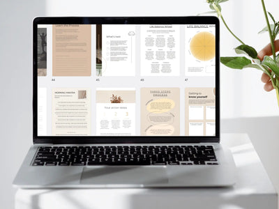 Laptop displaying a digital document on a white surface with a plant in the background
