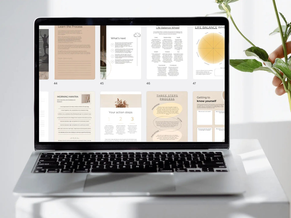 Laptop displaying a digital document on a white surface with a plant in the background