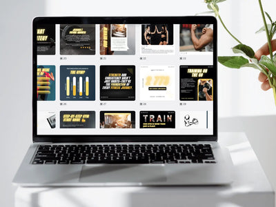 Laptop displaying a fitness-themed website on a white surface with a plant.