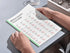 Person holding a check stub book on a light gray surface