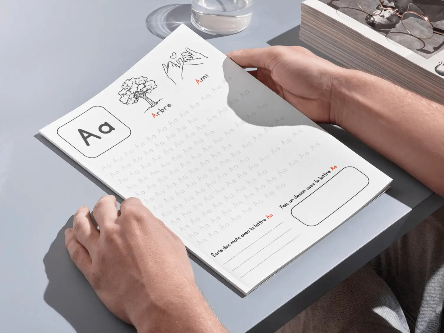 Person holding a notepad with educational content on a light gray surface