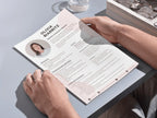 Person holding a resume on a light gray surface