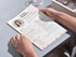 Person holding a resume on a light gray surface