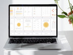 Laptop displaying a software interface on a white surface with a plant in the background