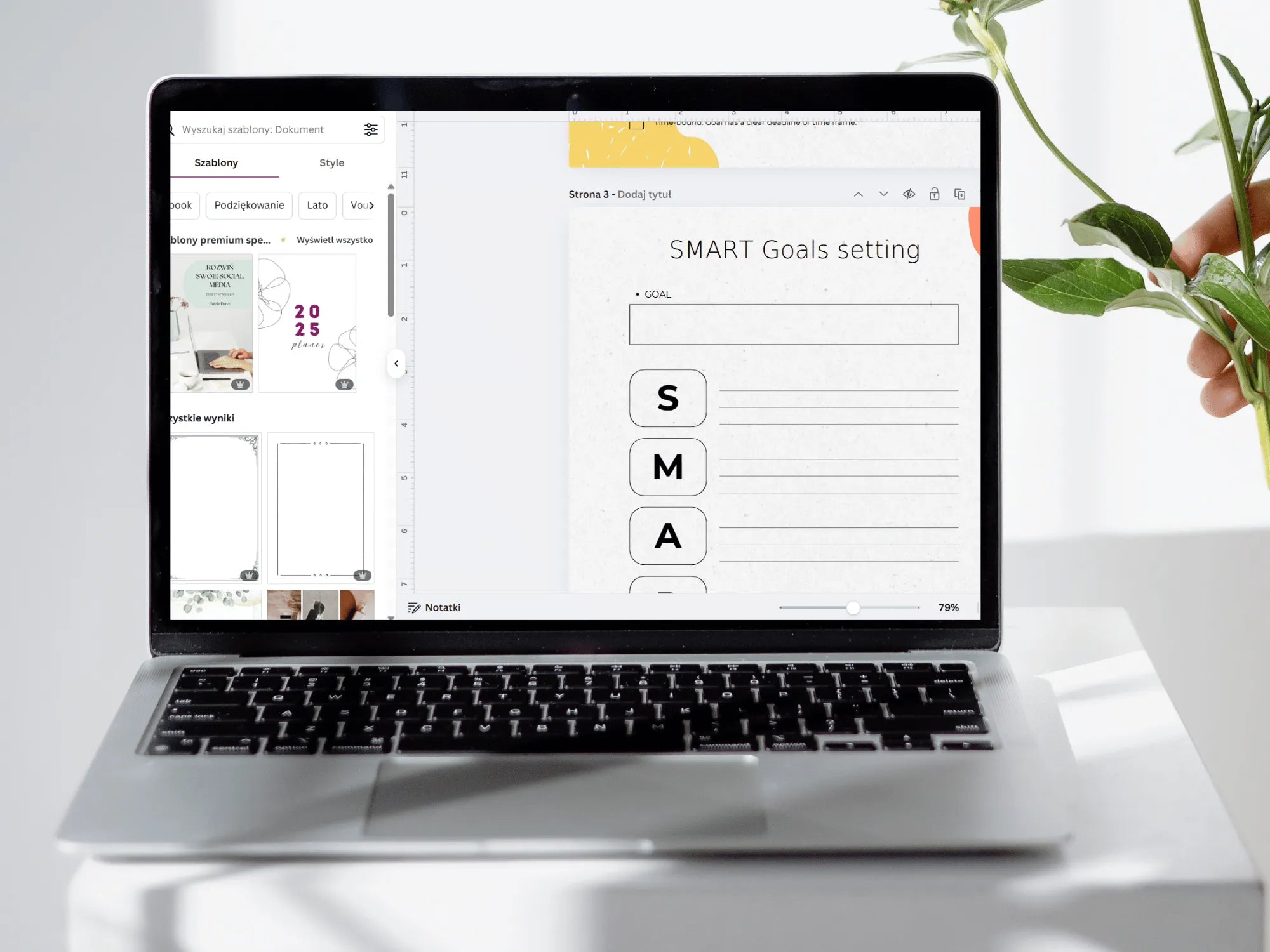 Laptop displaying a SMART Goals setting interface on a white desk with a plant.