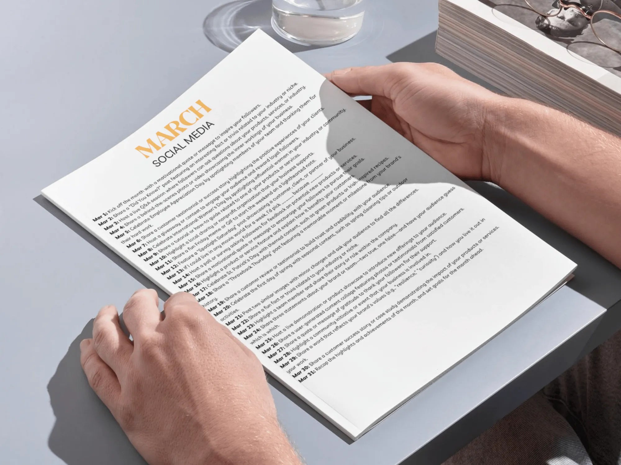 Person reading a document titled 'March Social Media' on a desk.