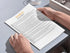 Person reading a document titled 'March Social Media' on a desk.