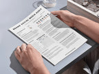 Person holding a brand social media audit document on a light gray surface