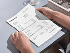 Person holding a check stub book on a light gray surface