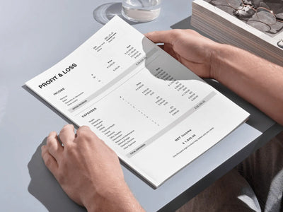 A person holding a high-quality printed version of the Profit & Loss statement at a desk, demonstrating its clean layout for physical bookkeeping and data-driven decisions