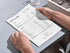 A person holding a high-quality printed version of the Profit & Loss statement at a desk, demonstrating its clean layout for physical bookkeeping and data-driven decisions