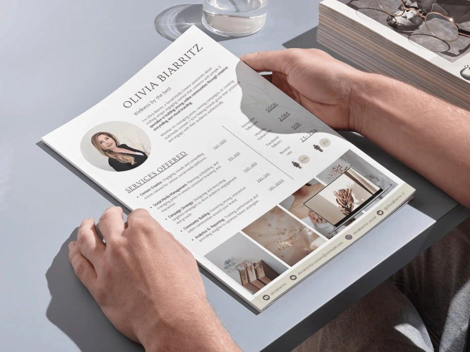 Person holding a resume with a professional layout on a light gray surface