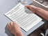 Person holding a checklist titled 'Keywords Research and Content' on a light gray surface.