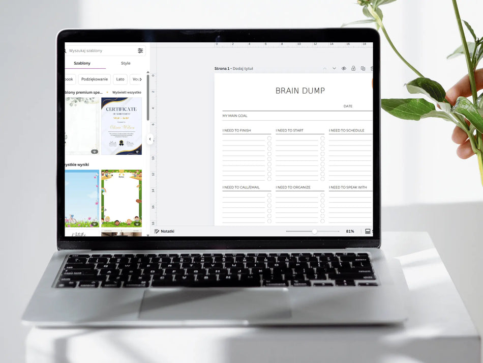Laptop displaying a to-do list app on a white surface with a plant in the background